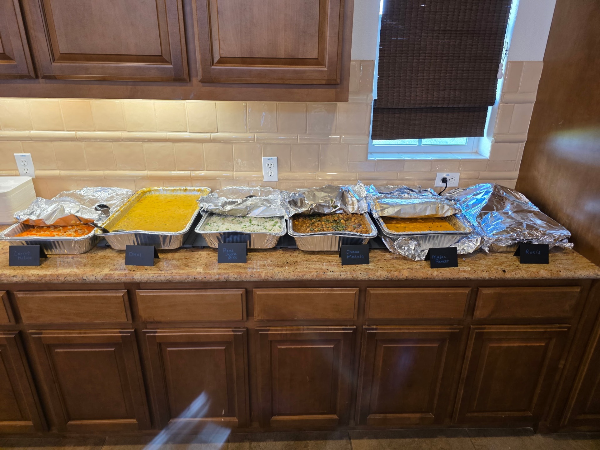 A spread of curries, dhal, and rice in serving trays